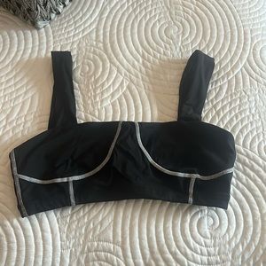 We Wore What black corset sports bra with white stitching